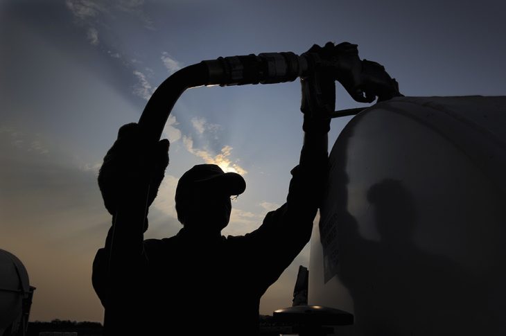 Man holding fuel line up to propane tank